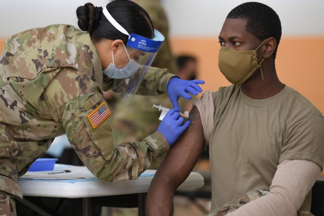 U.S. Army Spc. Eyza Carrasco, left, with 2nd Cavalry Regiment, administers a COVID-19 vaccination at the 7th Army Training Command&#39;s (7ATC) Rose Barracks, Vilseck, Germany, May 3, 2021. The U.S. Army Health Clinics at Grafenwoehr and Vilseck...
