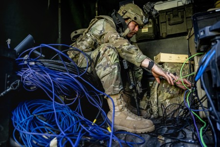 U.S. Army Spc. Dylan Horak, a network communication systems specialist with the 44th Expeditionary Signal Battalion – Enhanced, reconnects cables to a communication system after a drone attack during Saber Junction 23 at the Joint Multinational...