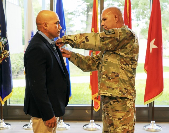 Maj.Gen. Ray Shields, the adjutant general of New York, presents the Bronze Star Medal with “V” device to retired Master Sgt. Luis Barsallo during a ceremony at the New York Division of Military and Naval Affairs headquarters in Latham, New...